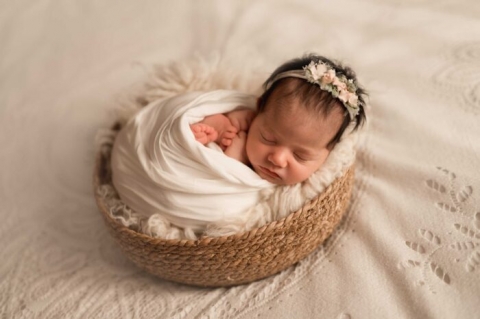 neonata che dorme pacificamente in un cesto